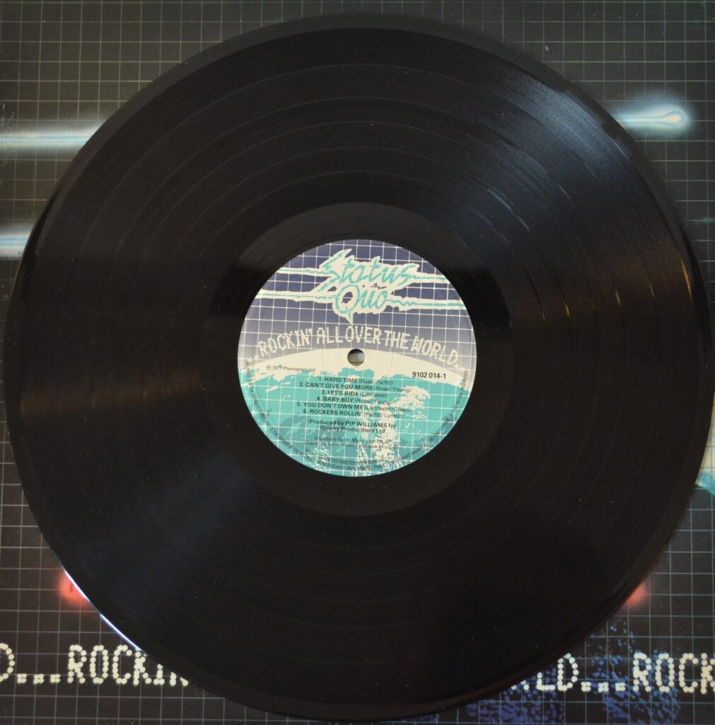 Status Quo - Rockin' All Over The World status-quo-rockin-all-over-the-world-record-side-one.
